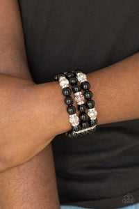 Paparazzi - Undeniably Dapper Black Bracelet - Pinched between white rhinestone encrusted frames, white rhinestone encrusted rings, crystal-beads, and shiny black beads are threaded along elastic stretchy bands for a glamorous look.  Sold as one individual bracelet. Paparazzi jewelry and accessories is  lead-free and nickel-free.   Fashion Fabulous Jewelry