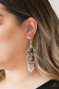 A brown teardrop bead sits atop stacked silver frames that are linked together to allow flowing movement. Featuring tribal inspired patterns, the dramatically stacked frames give way to flared rods for an edgy fringed finish. Earring attaches to a standard fishhook fitting.