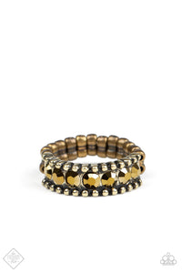 A single band Shiny brass stones and brass studs complete a single band ring with  an elastic band.