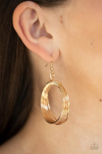 Dainty gold wire delicately wraps around layers of coiled gold wire, creating an edgy hoop. 