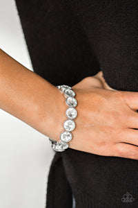 Number One Knockout  White Rhinestone Bracelet - Paparazzi Accessories - Paparazzi Accessories Faceted white gems are pressed into sleek silver frames.  The glittery frames are threaded along elastic stretchy bands, creating a glamorous look around the wrist.  